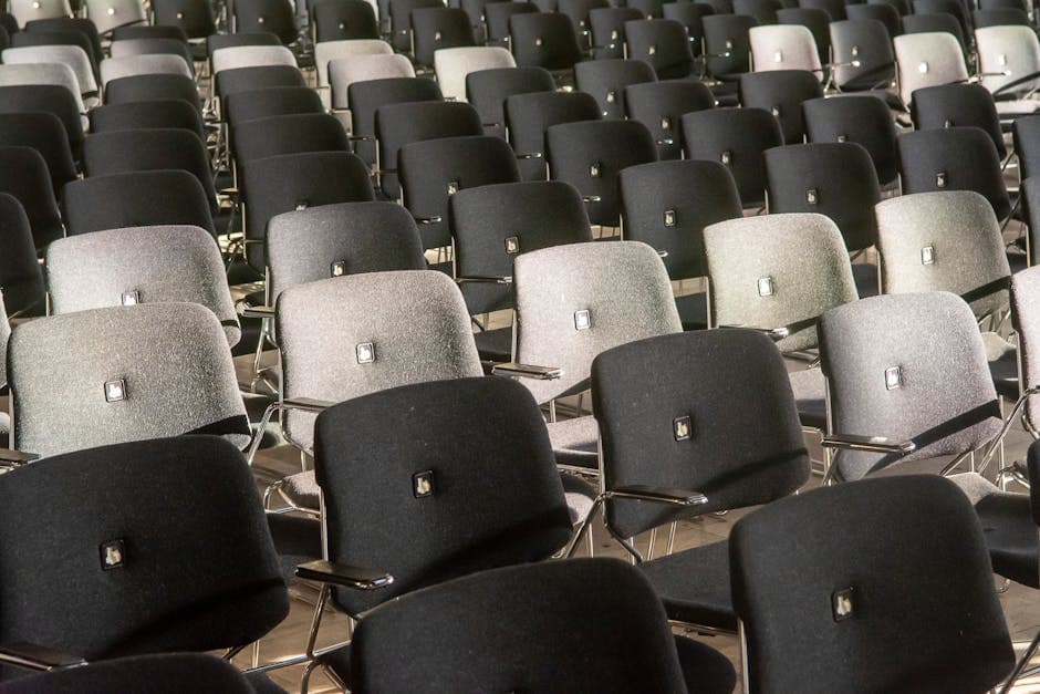 Rows of black and gray chairs in an auditorium, showcasing comfort and style.