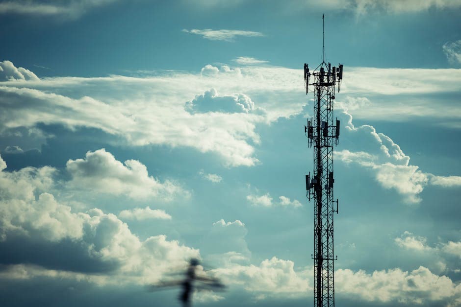 A tall communication tower silhouetted against a bright, cloudy sky, symbolizing connection.