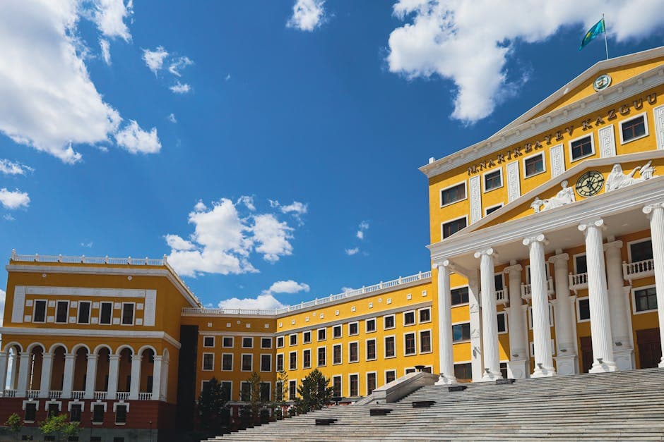 Stunning architectural facade of a university in Kazakhstan against a vibrant blue sky.