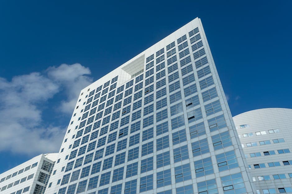 Impressive low-angle shot of modern skyscraper in The Hague, Netherlands against a clear blue sky.