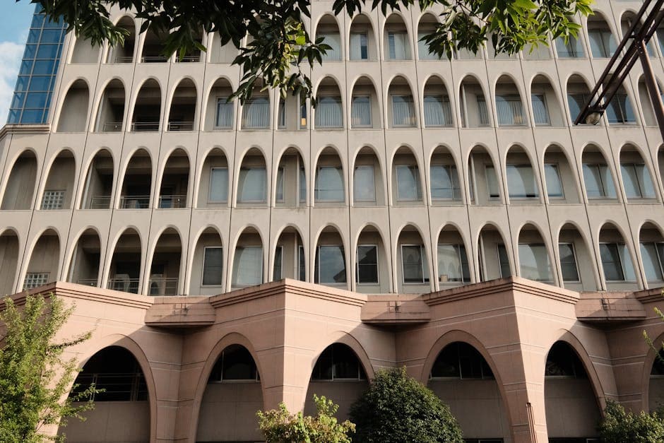 Exterior view of a modern building featuring arched windows and geometric design.