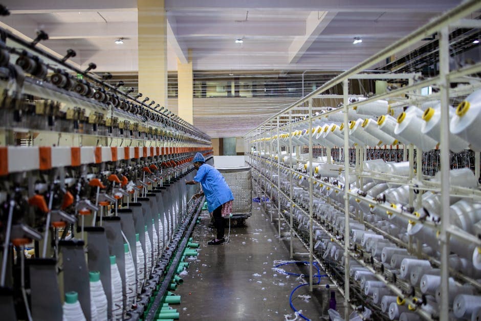 A textile worker handling machinery in a modern factory setting.