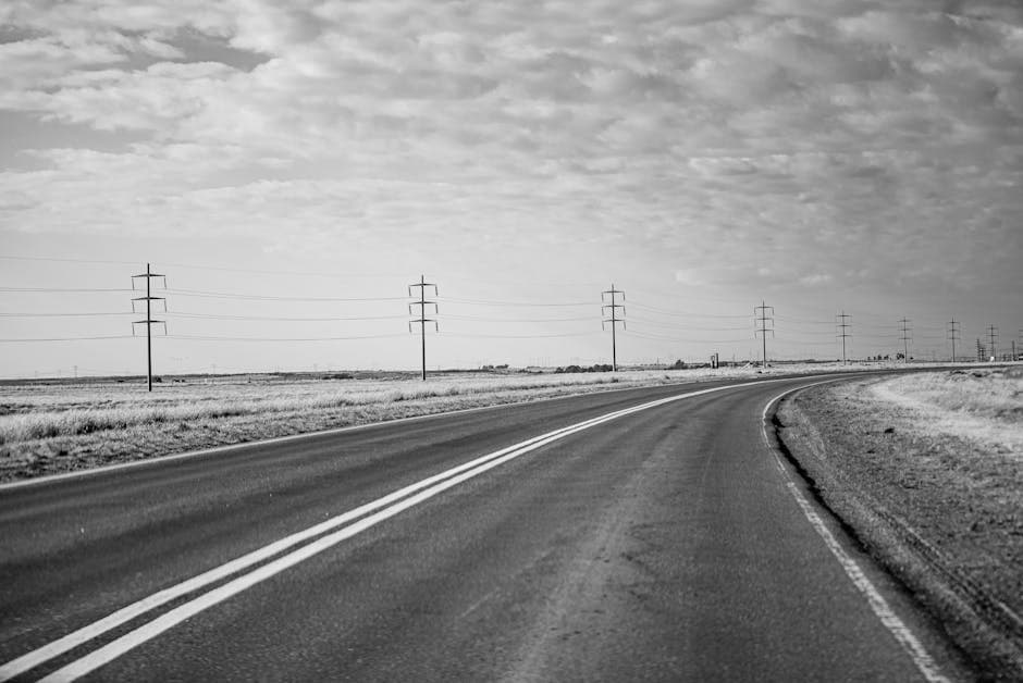 Black and white photo of a long empty road with power lines in Bahía Blanca, Argentina.