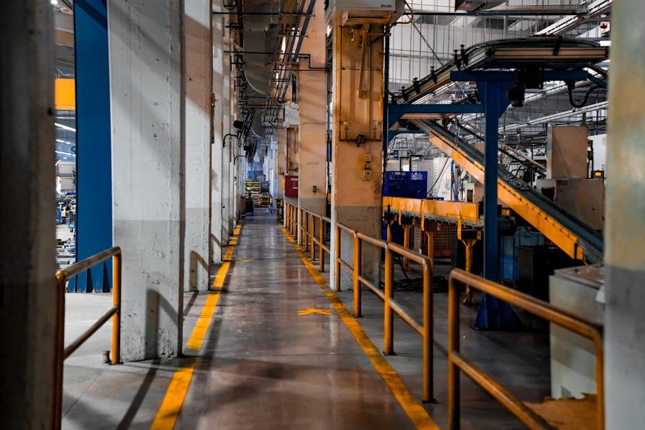 Inside view of an industrial factory featuring conveyor belts and empty walkways.