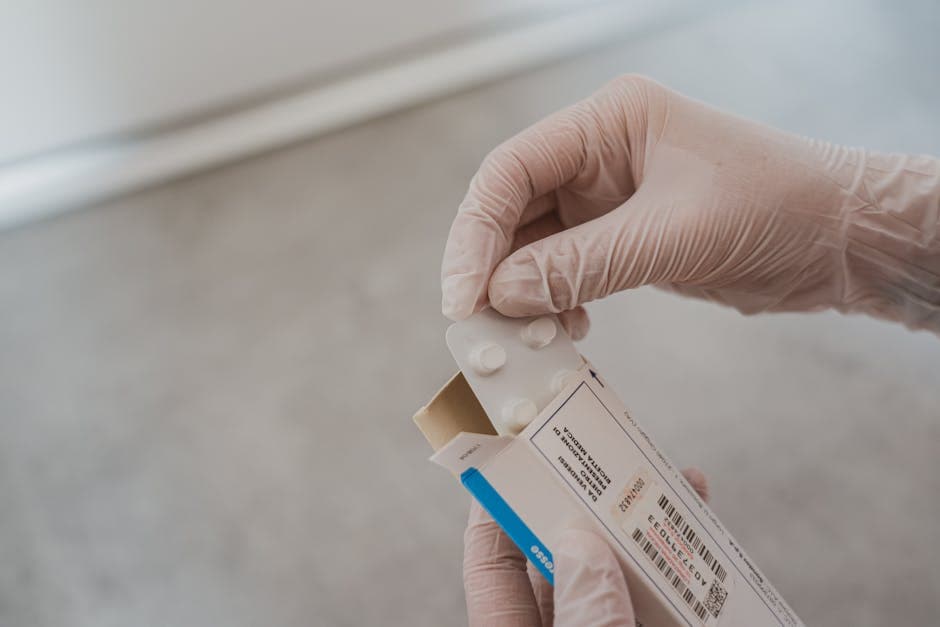 Close-up of hands in gloves handling medication blister pack, ensuring safety and hygiene in healthcare.