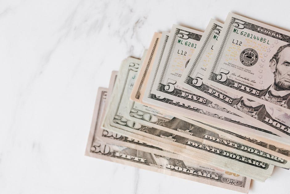 Top view of stack of US dollar banknotes in different denominations on marble table