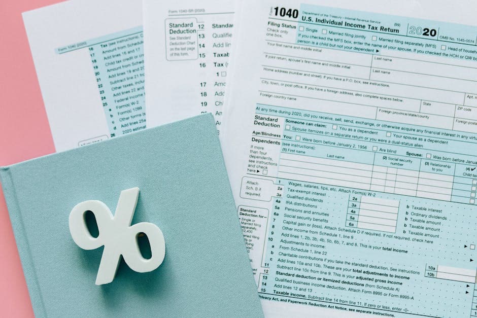 Tax documents with a percentage symbol on a pink and blue desk setup, emphasizing finance.