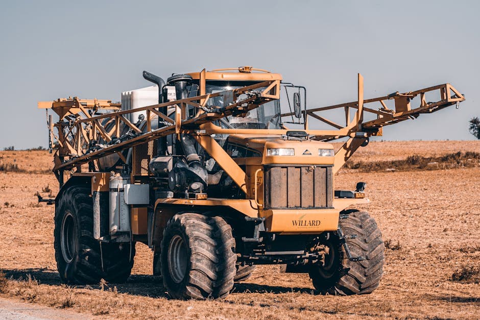 A self-propelled agricultural sprayer in a vast field showcasing modern farming technology.