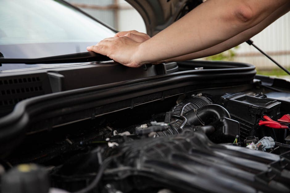 Close-up of hands working on car engine. Detailed view of automotive repair.