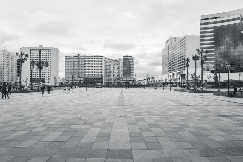 Black and white cityscape of Tangier with buildings and people walking.