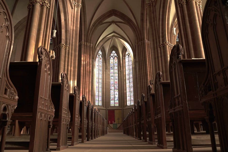 Interior view of a gothic church in Oppenheim, showcasing arches, pews, and stained glass windows.