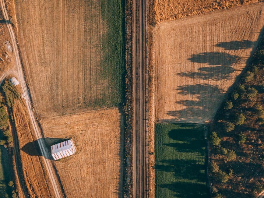 Drone shot of Alpagut, Turkey, showcasing fields, railway, and rural scenery.