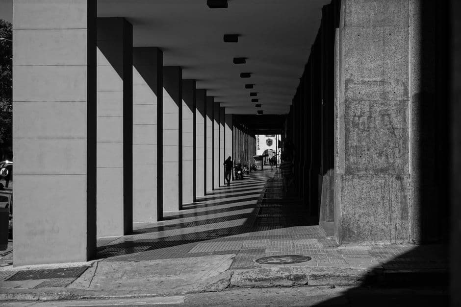 Black and white photo of a shaded passageway with columns in Buenos Aires, Argentina.