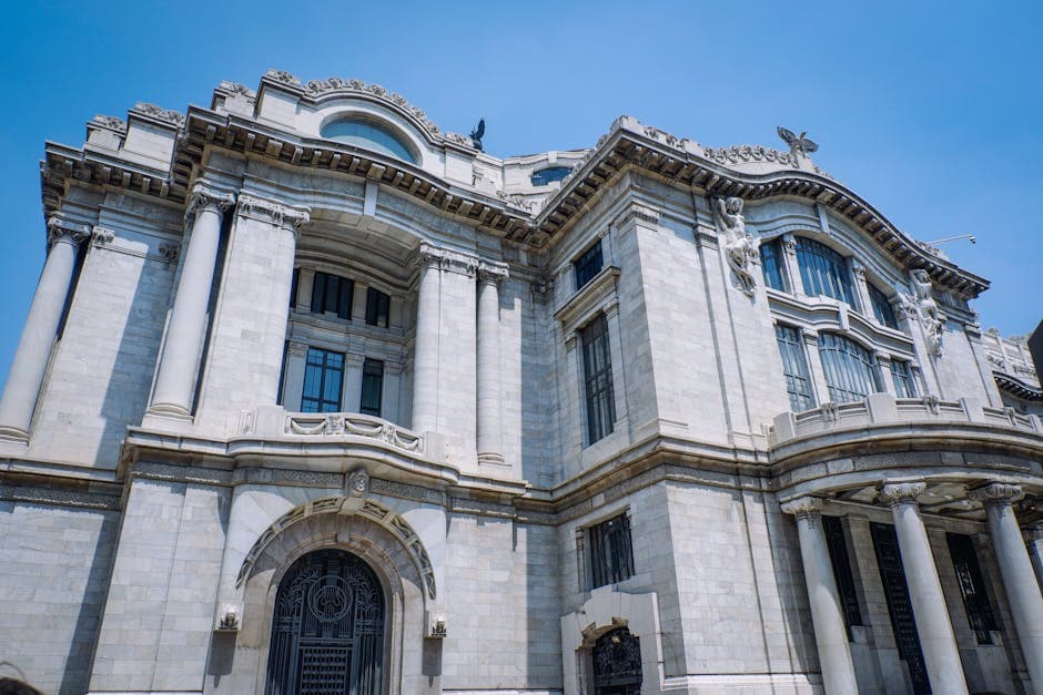 Stunning view of the neoclassical architecture of Palacio de Bellas Artes under a clear blue sky in Mexico City.