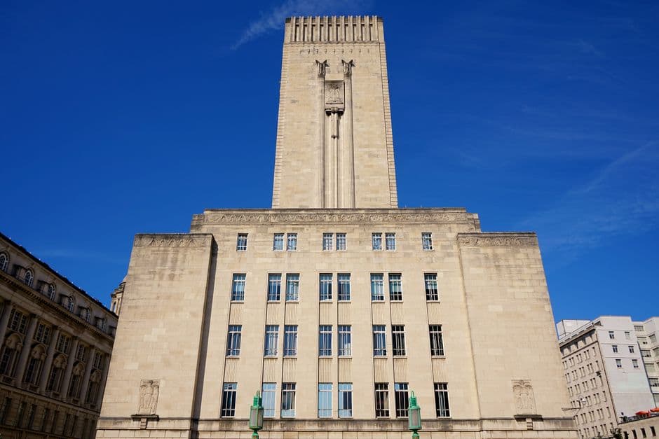 A stunning low angle view of Liverpool's iconic tower under a bright blue sky.