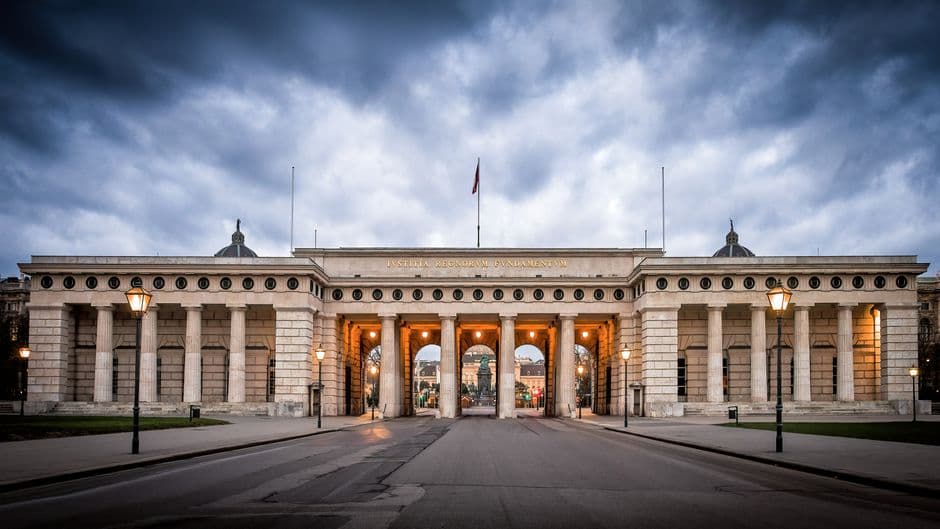 Classic architectural gate with columns under dramatic clouds, an iconic tourism landmark.