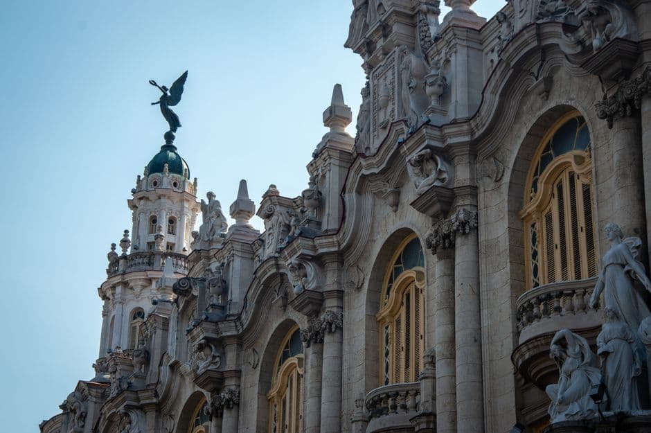 Ornately detailed baroque building captured from a low angle against a clear blue sky.