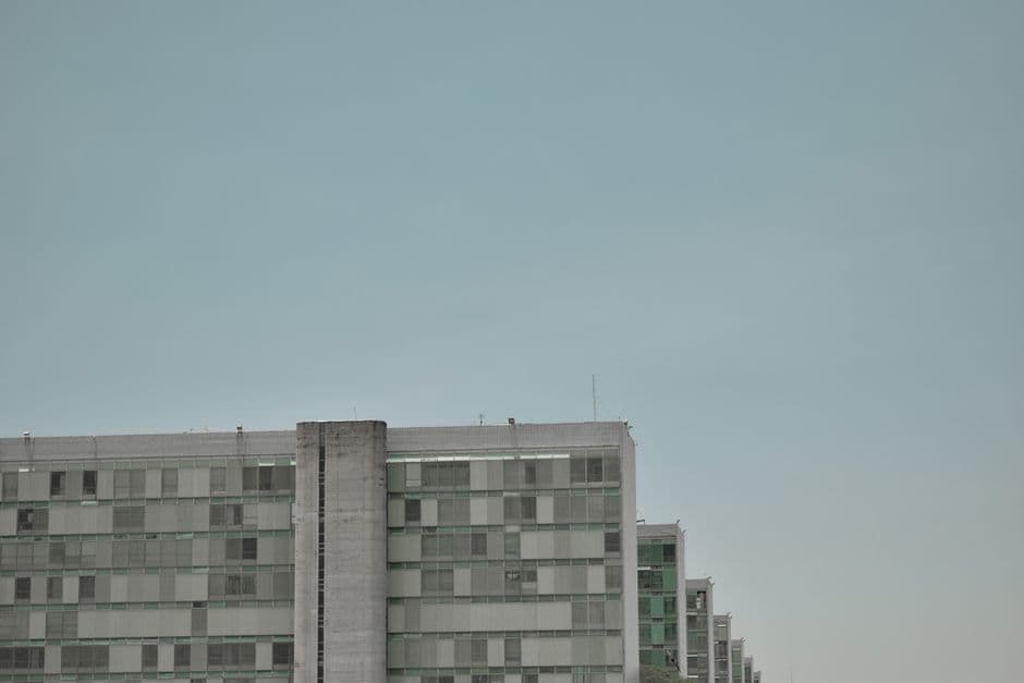 Contemporary office building exterior against a clear blue sky, showcasing modern design.