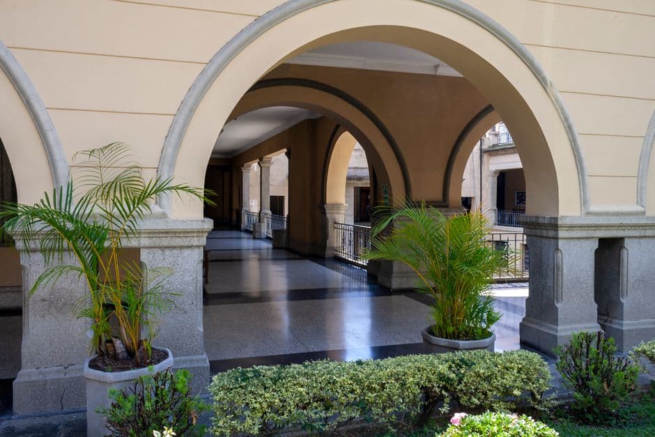 Beautiful archways and greenery in a serene corridor setting in Mérida, Venezuela.