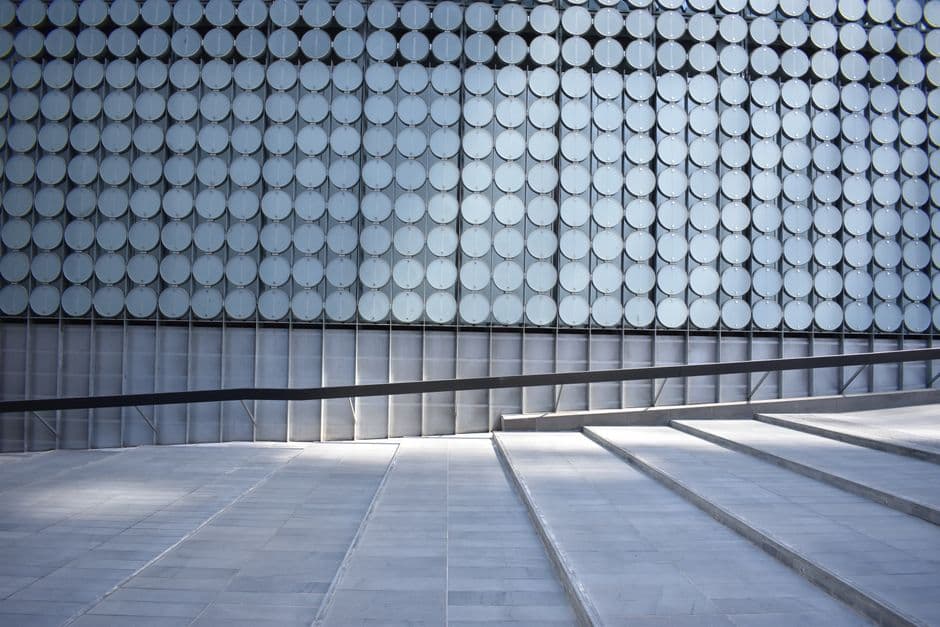 Intricate modern architecture featuring geometric patterns and steps in an urban setting.