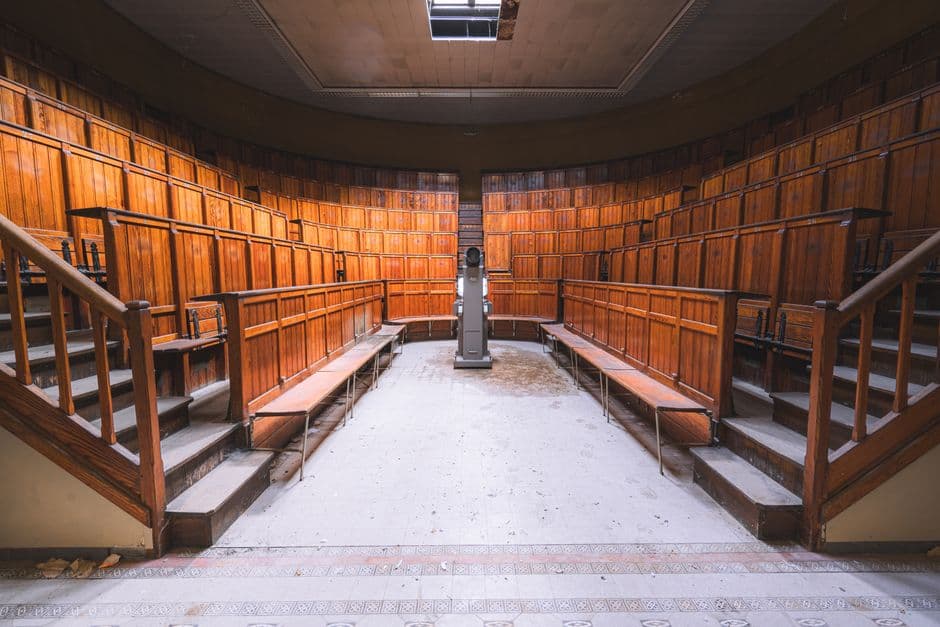Explore the rustic charm of this vintage wooden amphitheater classroom with unique seating and lectern.