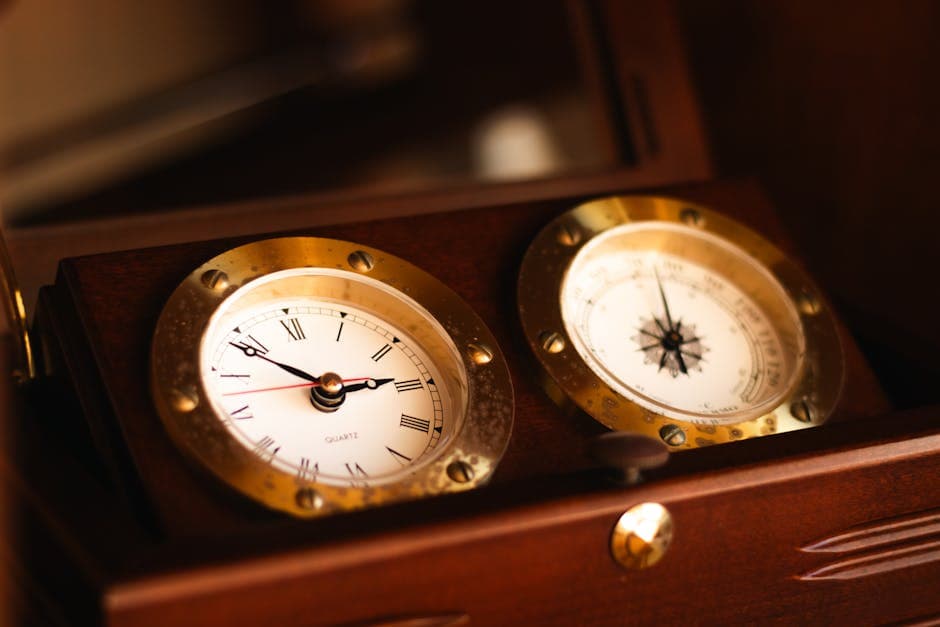 Close-up of a vintage nautical clock and compass in a wooden case.