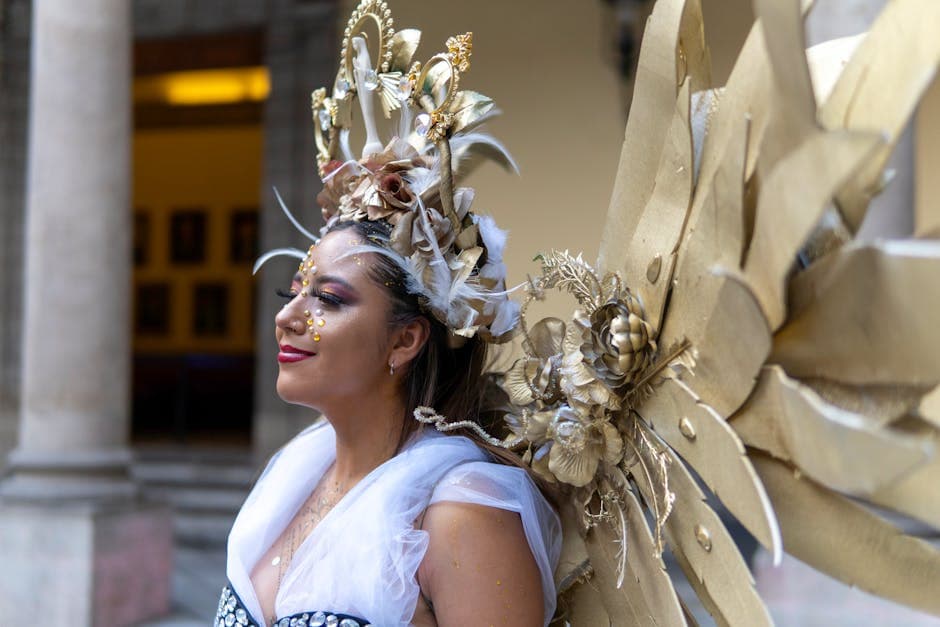 Portrait of a woman in an elaborate golden costume with artistic makeup and headpiece.