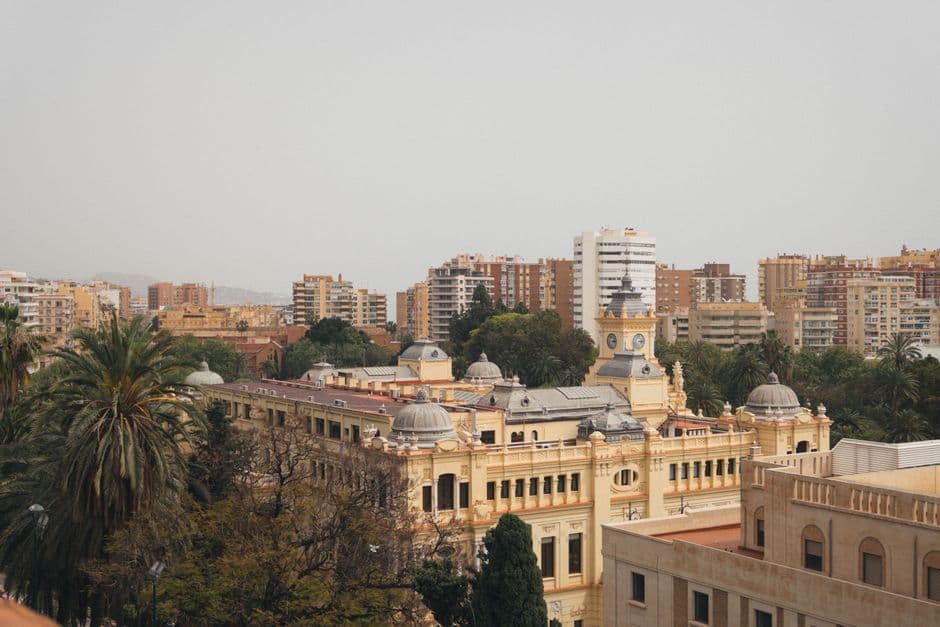 Aerial view of Málaga's historic town hall and cityscape under a clear sky.