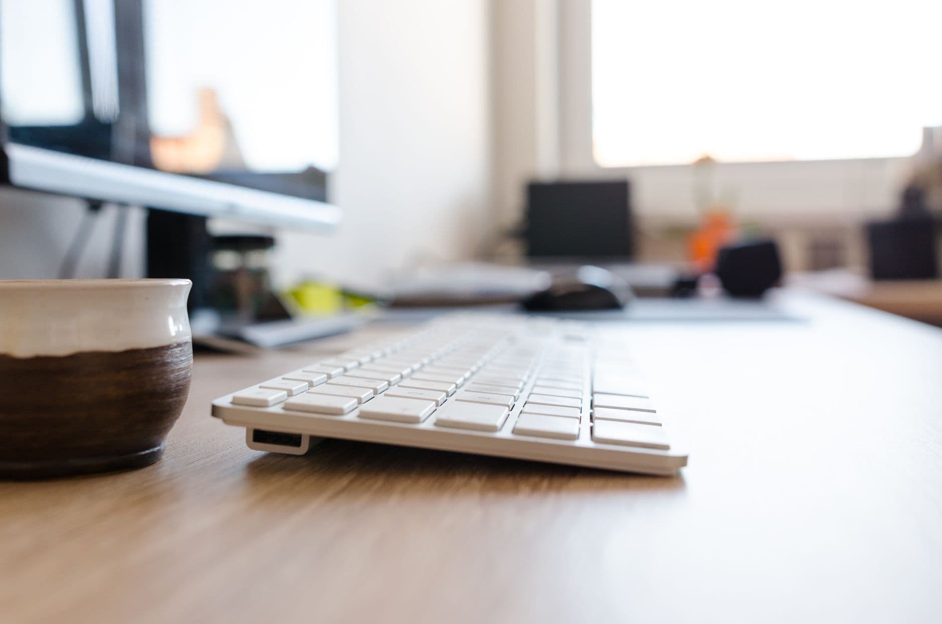Modern office desk setup featuring a computer keyboard and monitor, ideal for workspaces.