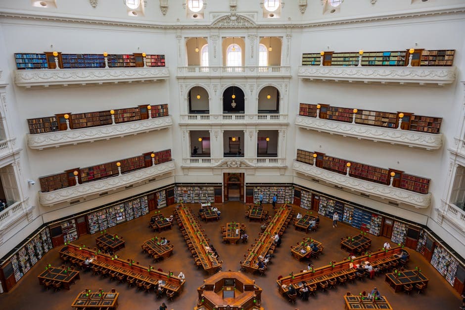 Elegant library interior featuring multi-level bookshelves and reading desks under soft lighting.