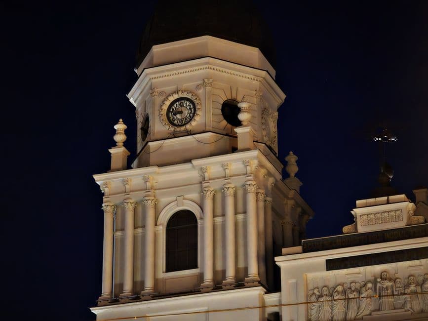 Night view of a historic clock tower in Iași Romania showcasing European architecture.