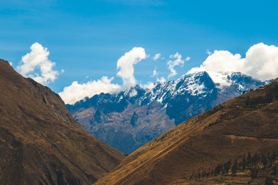 Breathtaking view of snow-capped Andes mountains under blue skies in Cusco, Peru.