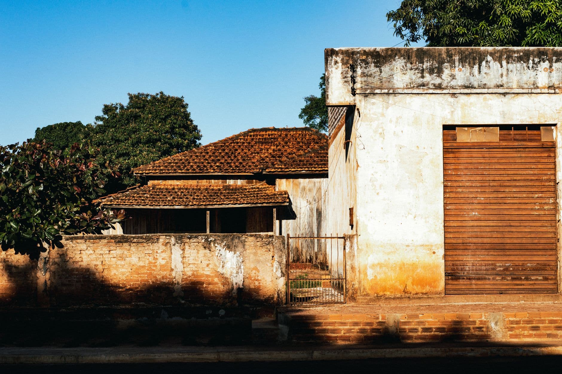 Old brick house with wooden roof and aged wall in bright daylight.