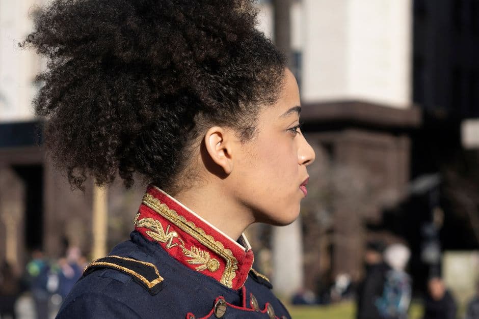 A woman in ornate uniform stands on a sunny day in Buenos Aires, Argentina.