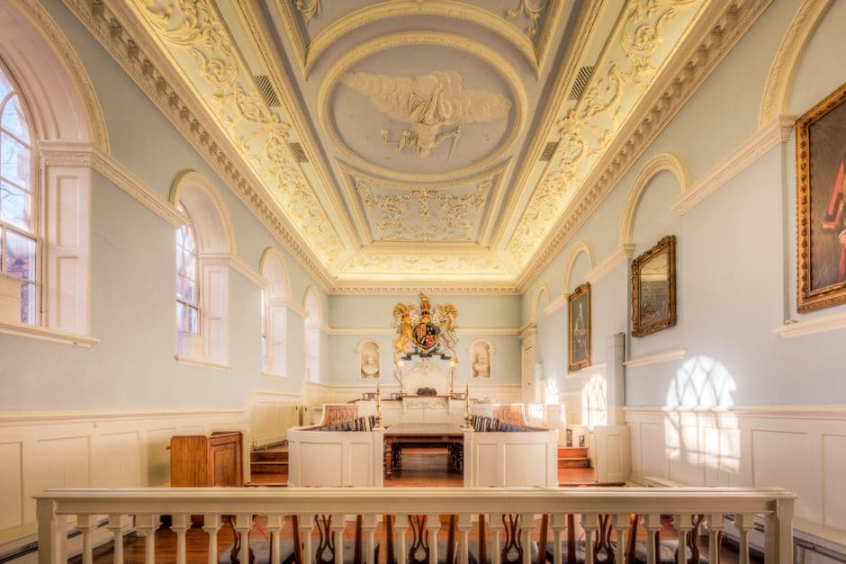 Explore the elegance of a historic courtroom in England featuring an ornate ceiling and classic decor.