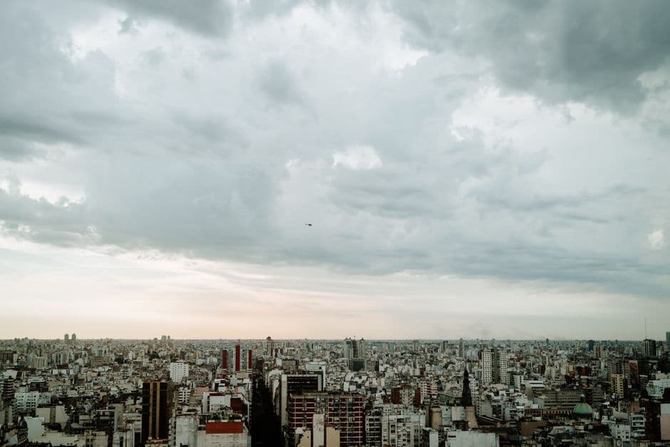 A panoramic aerial view of Buenos Aires skyline under a cloudy sky, emphasizing urban density.