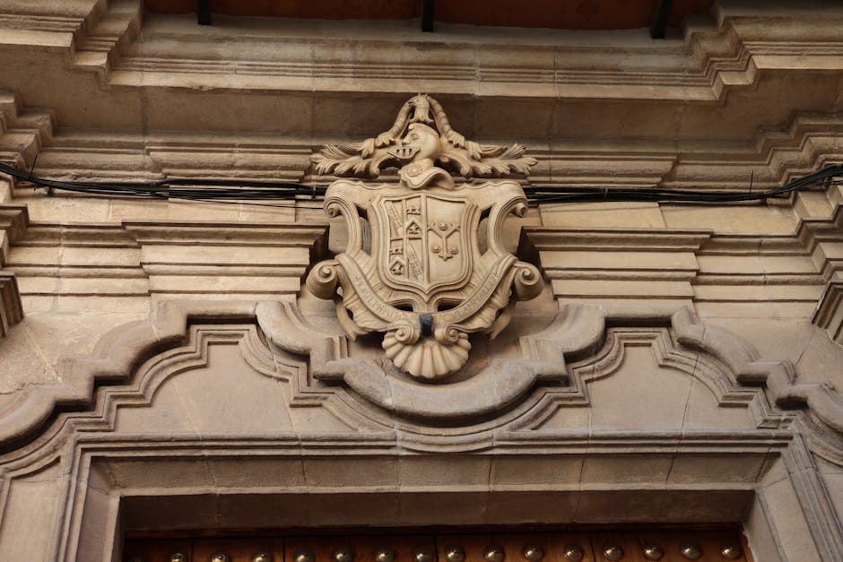 Detailed stone crest on a historic building in El Puerto de Santa María, showcasing intricate craftsmanship.
