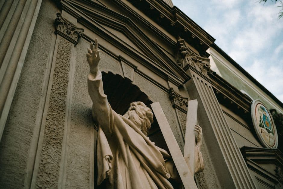 Detailed view of a historical statue on an ornate Renaissance Revival building facade.