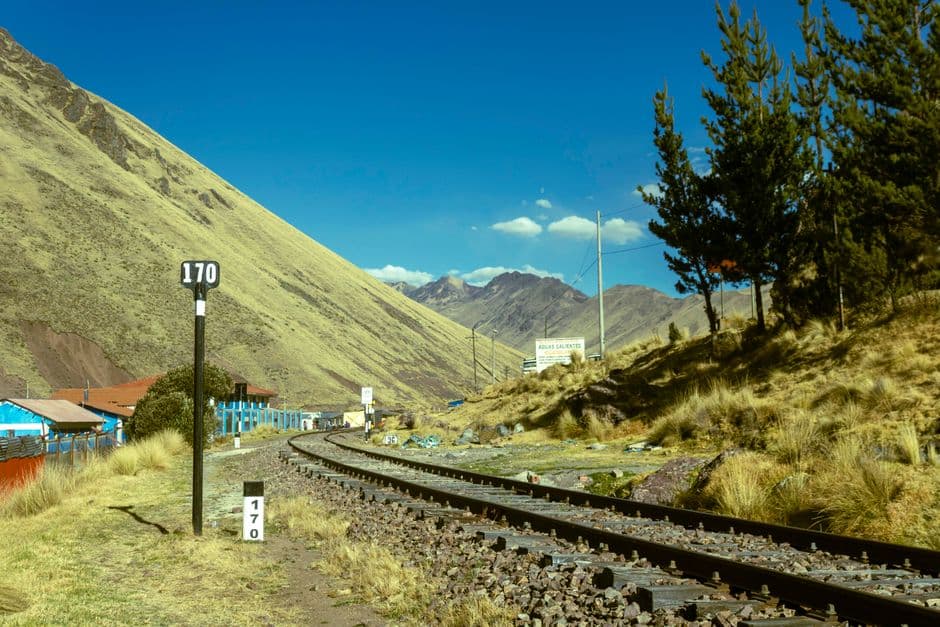 Railway track winding through the vibrant landscapes of Cusco, Peru, showcasing stunning mountain views.