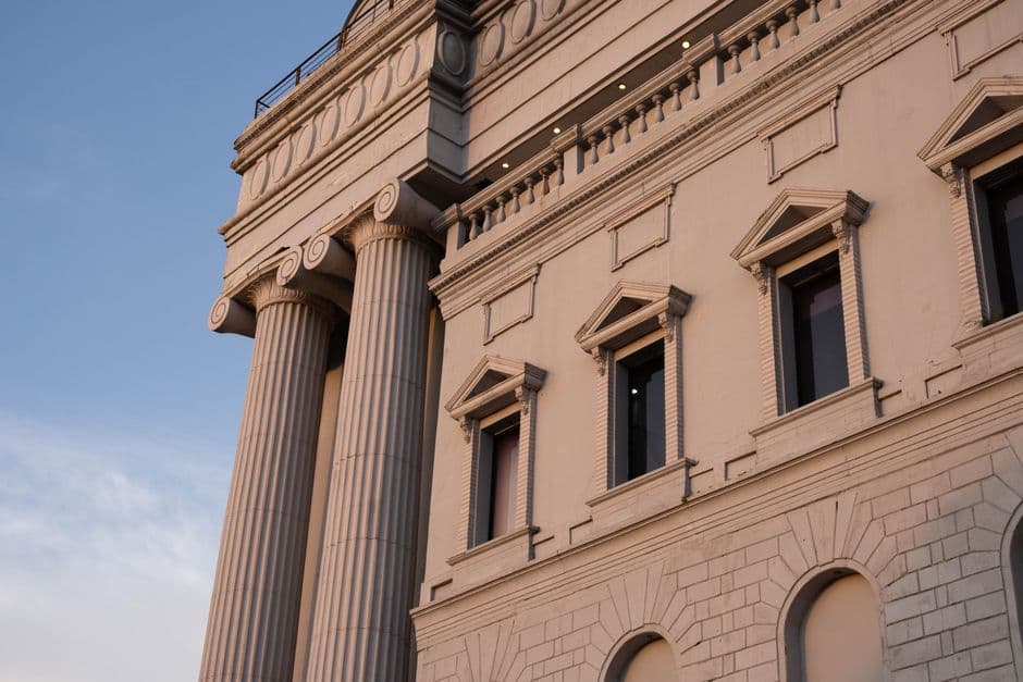 Elegant facade with Corinthian columns showcasing classic architecture against a clear sky.