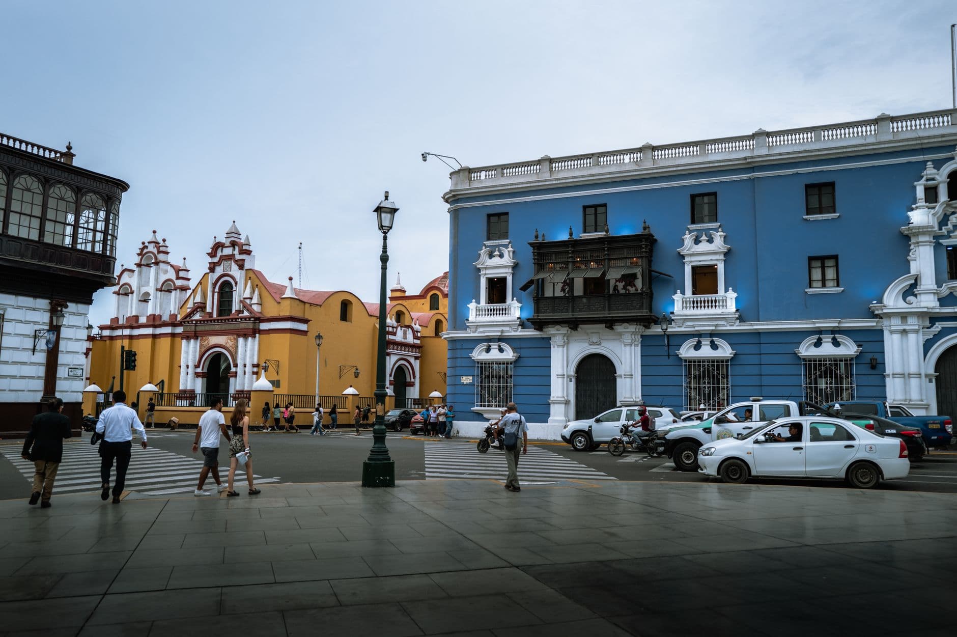 Street view of colorful colonial buildings and pedestrians in Trujillo, Peru.