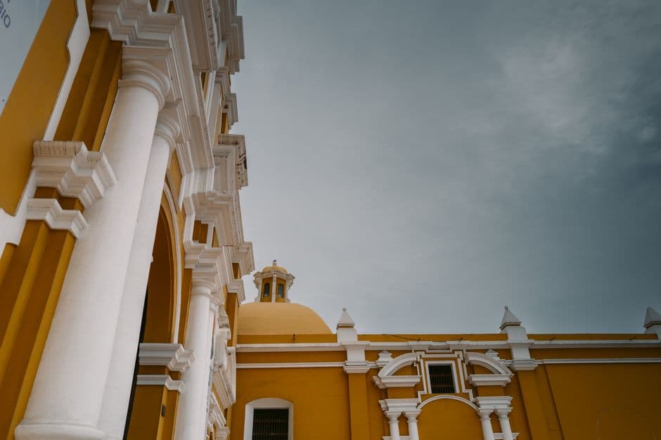 Vibrant colonial architecture of a historic building in Trujillo, Peru captured under a cloudy sky.