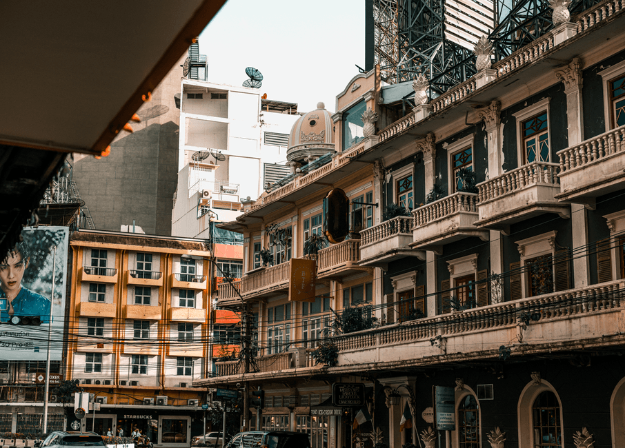 Charming street view in Bangkok showcasing historic architecture and urban life.