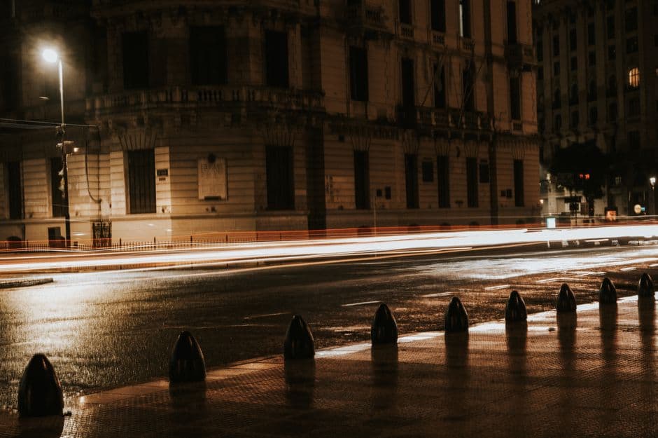Long exposure night shot of city street with light trails and classic architecture in Buenos Aires.