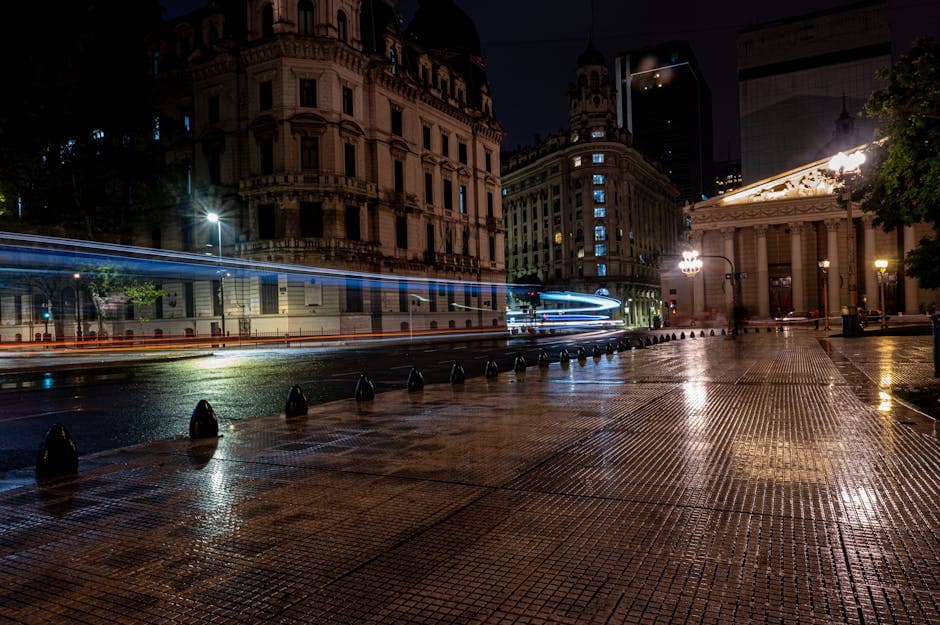 Vibrant nighttime cityscape of Buenos Aires featuring blurred traffic lights and historic architecture.