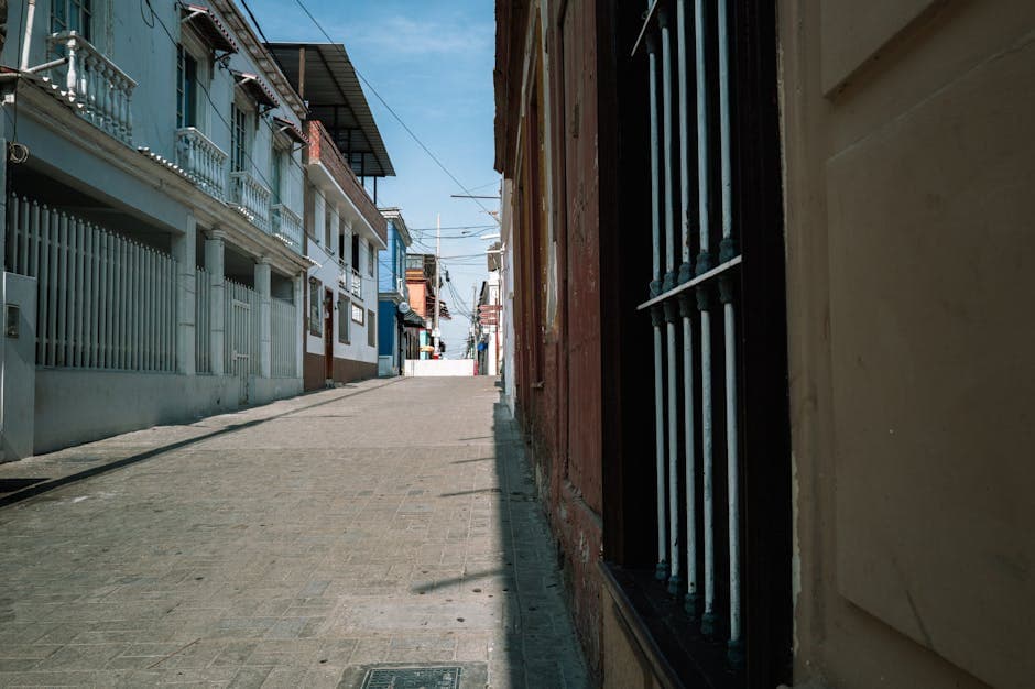 Quiet street in Pacasmayo, Peru showcasing colorful architecture during daytime.