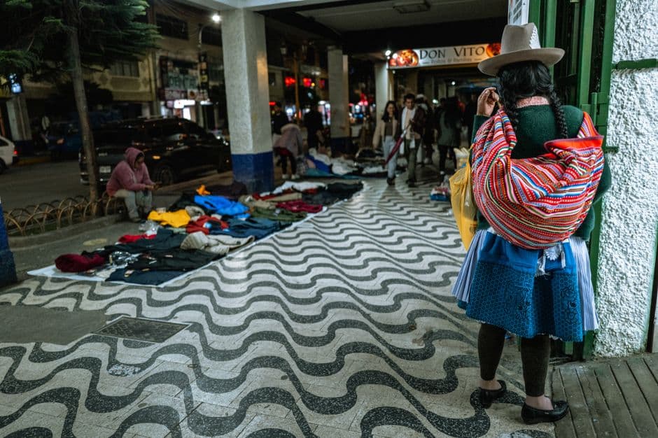 Candid night street scene featuring a woman in traditional attire in Trujillo, Peru's vibrant evening market.