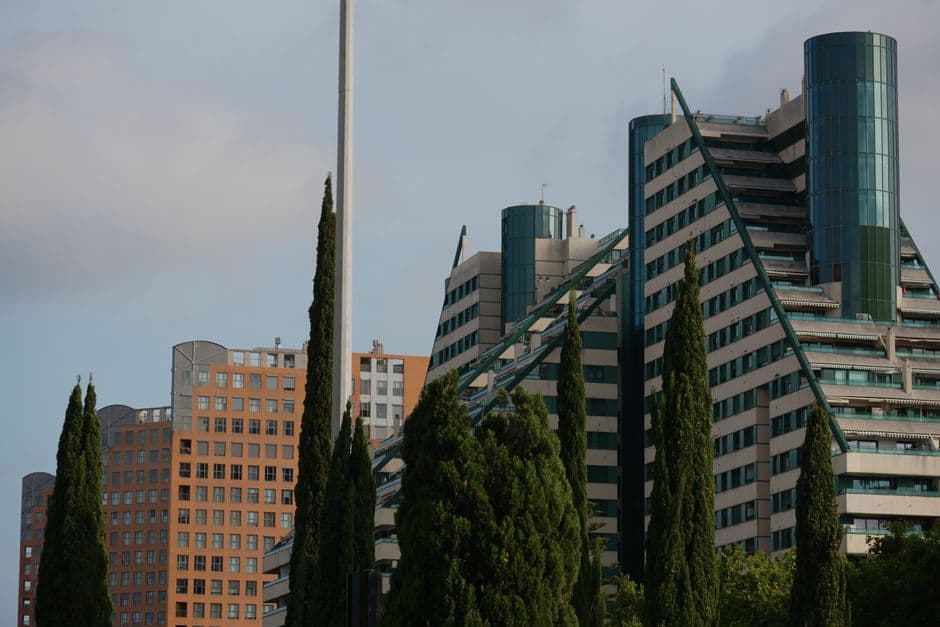 Stunning view of unique modern architecture buildings in Valencia, Spain amidst tall trees.