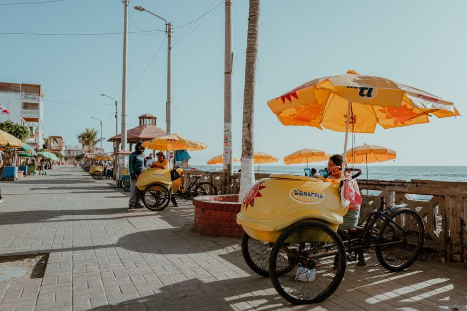 Sunny day at Pacasmayo seafront, Peru, with vibrant yellow parasols and seaside views.