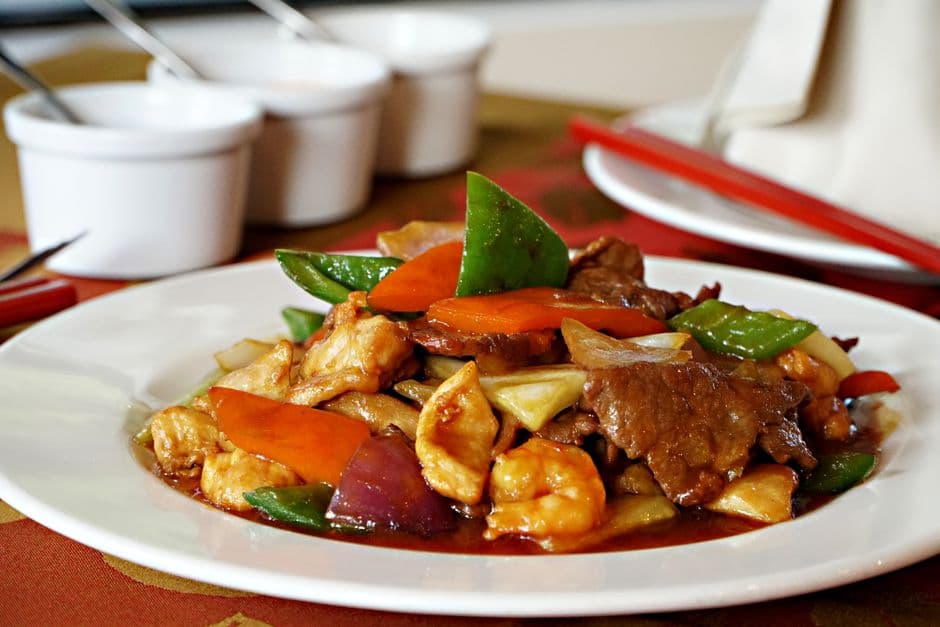 Savory Peruvian stir fry featuring beef, chicken, and vibrant vegetables, elegantly plated.